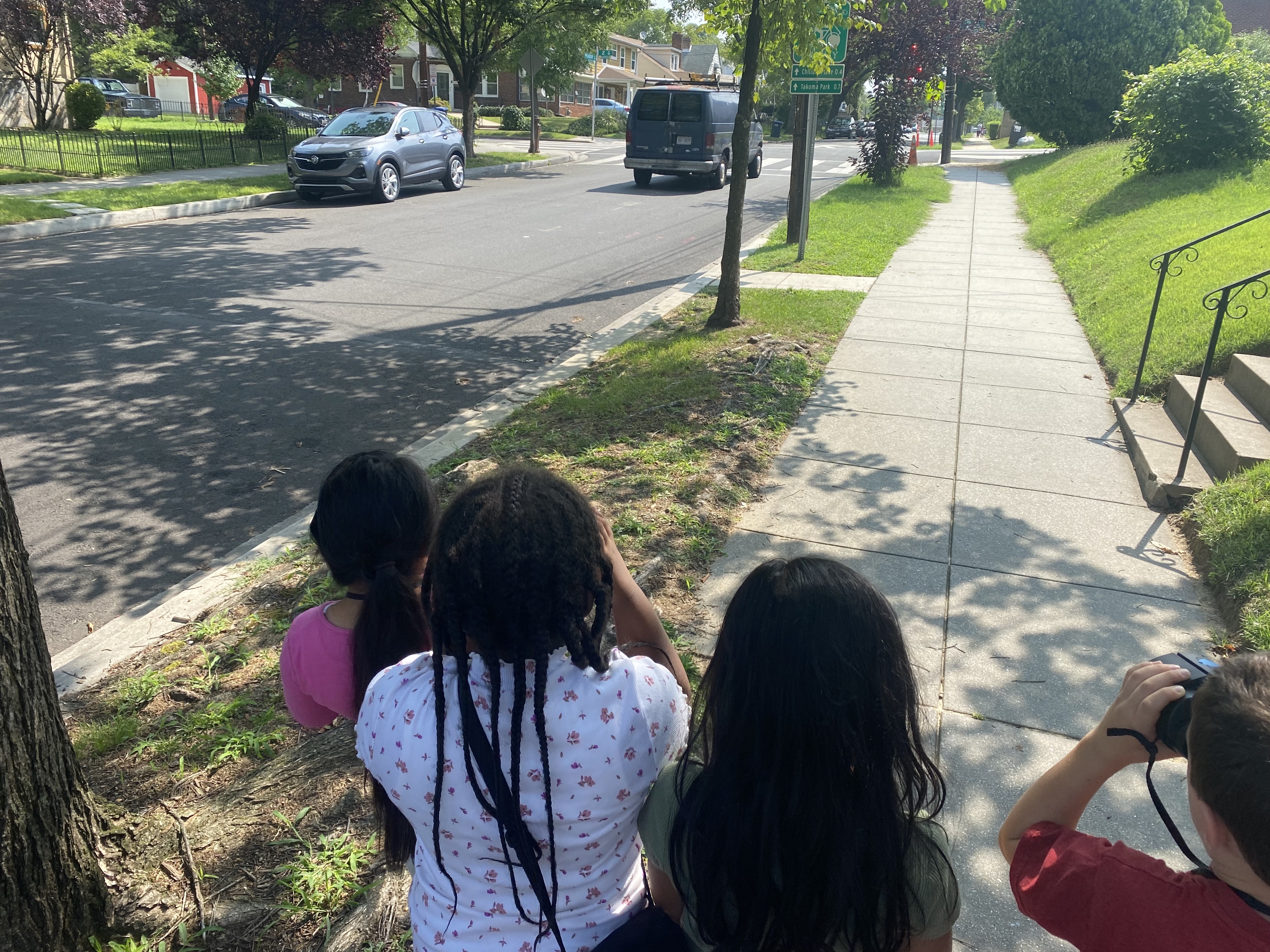 Kids walk down a sidewalk looking for signs of birds